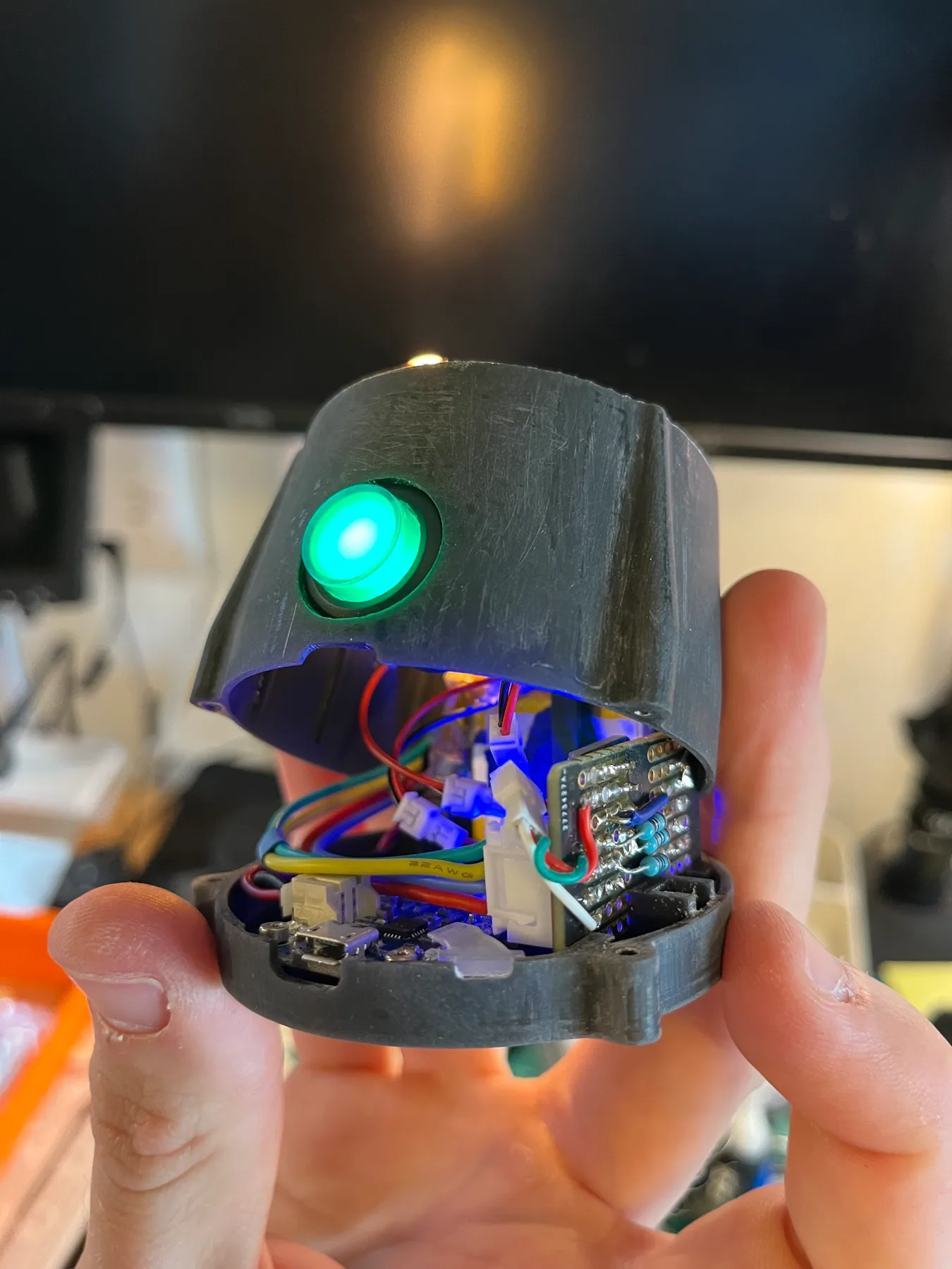 Inside the base: the power circuit, wiring, and backlit button.