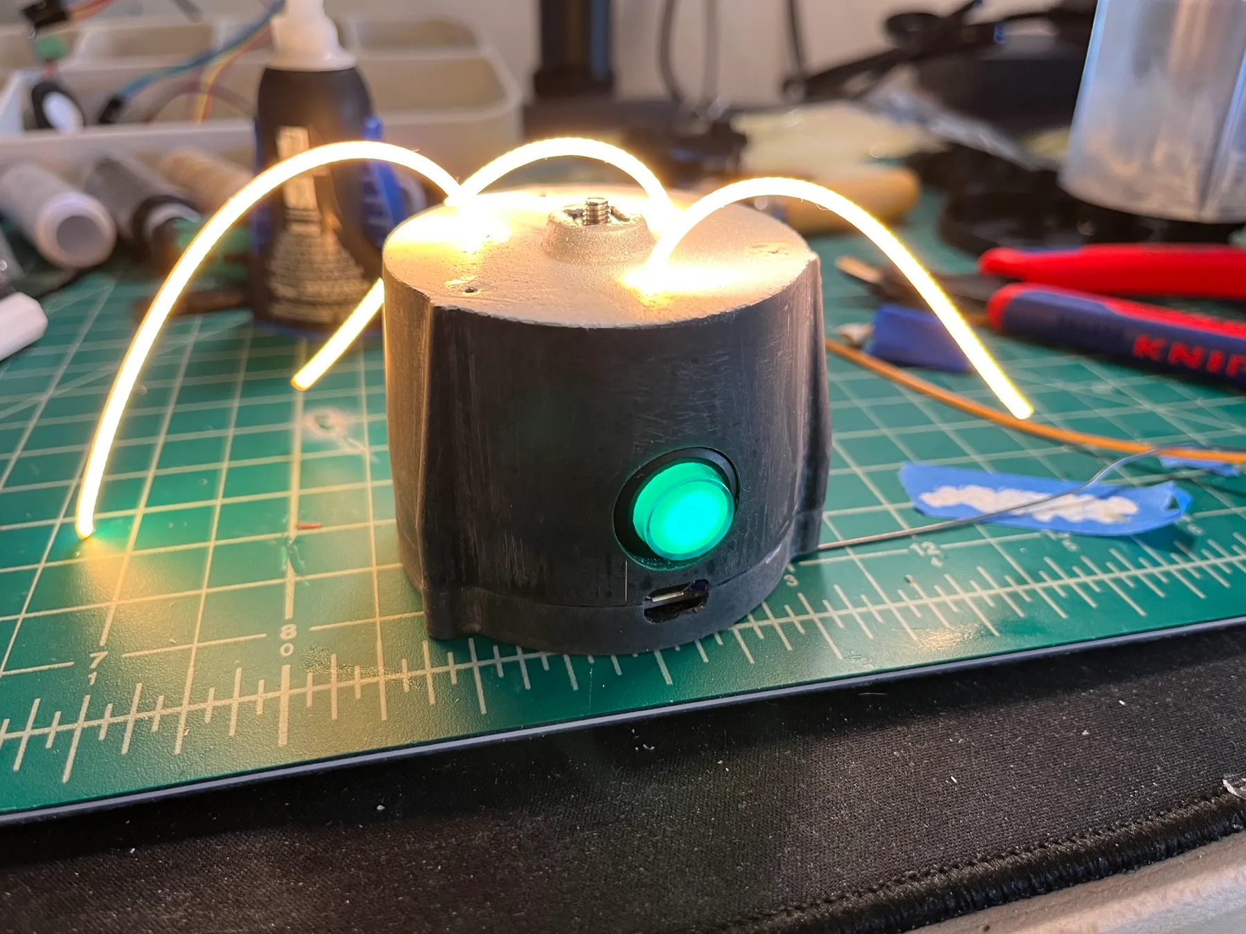 Three flexible LED filaments glowing before the enclosure is assembled.
