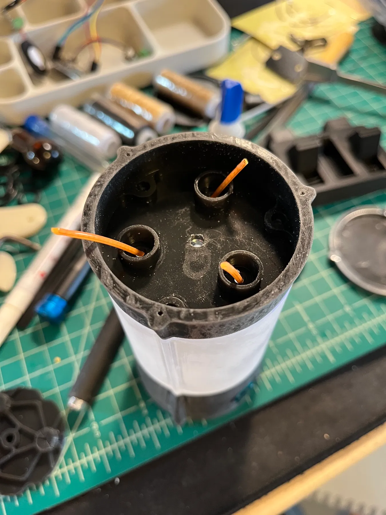 The upper plate with three filament retainers and a central bolt.