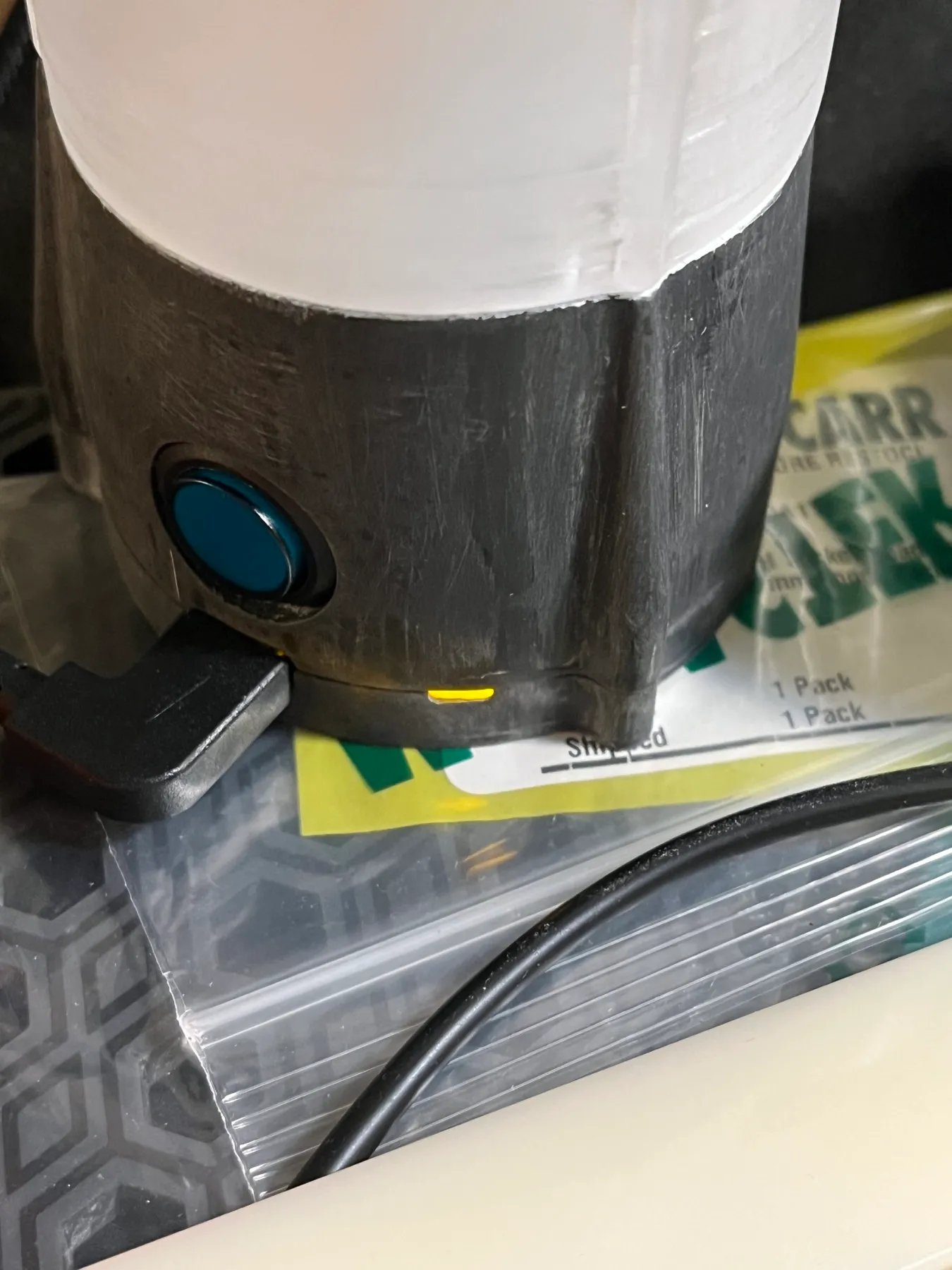 The button and USB charging connection at the base of the lamp.