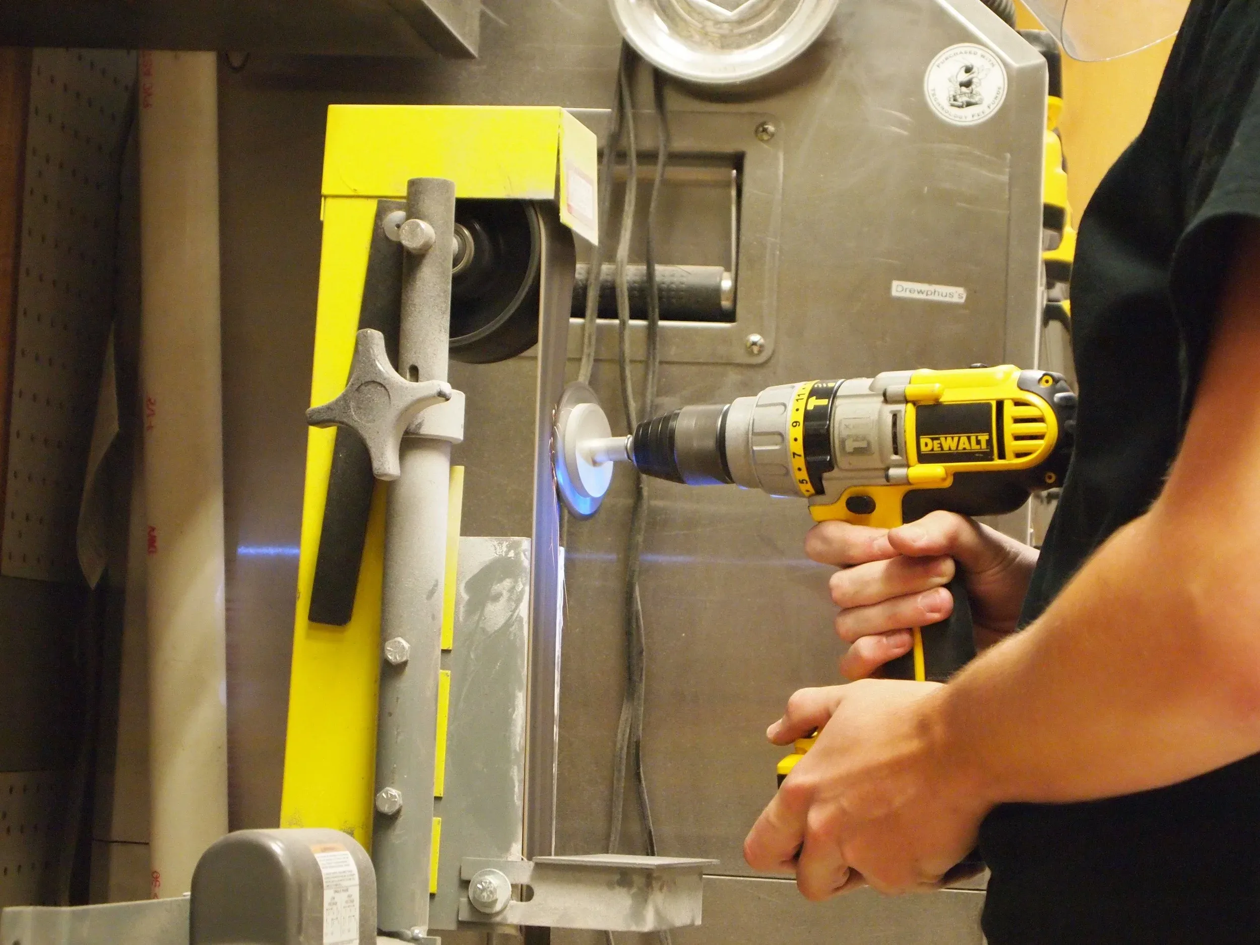 Using a belt sander to put a slight bevel on the teeth of the sprocket, which was cut on a waterjet.